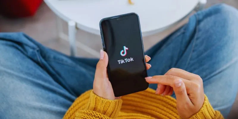 A person navigating TikTok settings on a smartphone